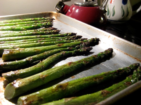Roasted asparagus spears line a baking sheet, fresh from the oven.