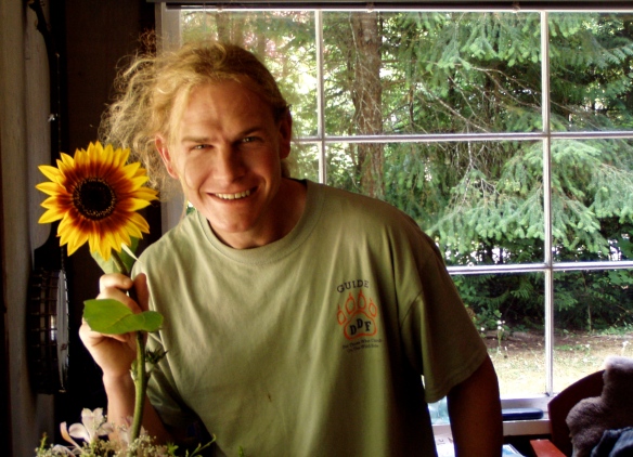 Andy with organic sunflower grown on Gabriola Island, BC, July 2003.