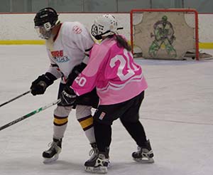 Retired kindergarten teacher, Ceci takes onretired fireman, Dave for the puck at Learn-to-Play Hockey at Campion Rink.