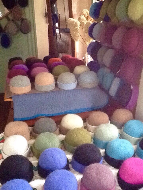 Recently felted & hand-shaped, felt hats in every color dry in the home studio of NH fiber artist, Carrie Cahill Mulligan.